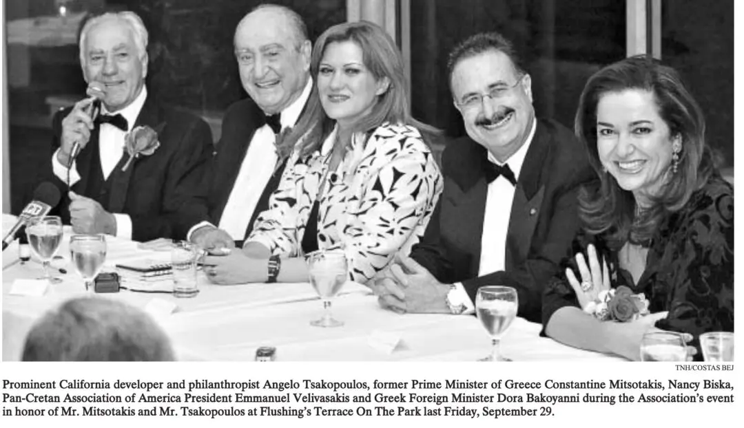 Three people in formal attire smiling at a dinner event.