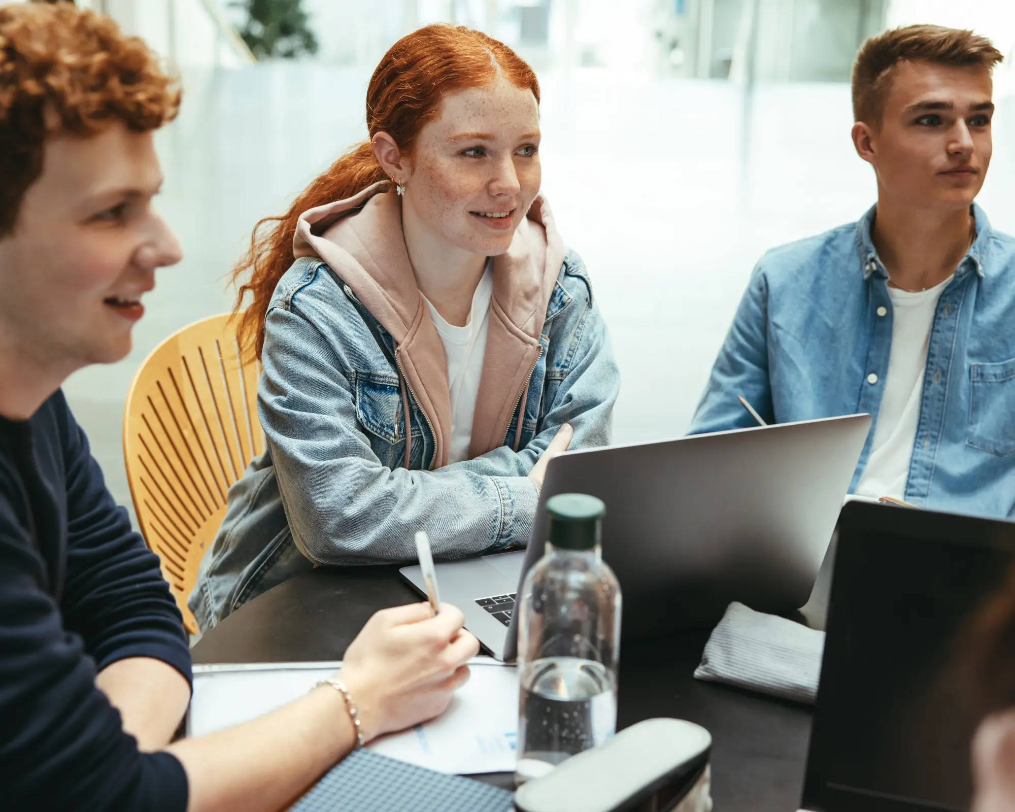 Group of young adults collaborating at table.