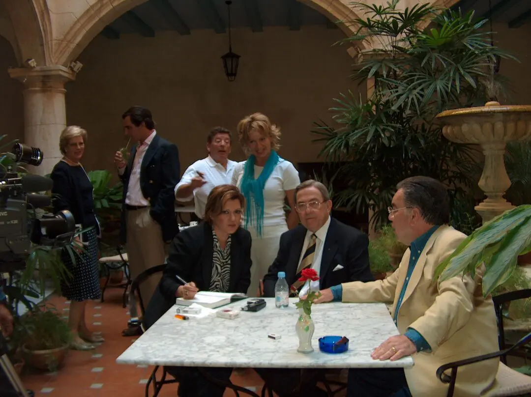 People socializing at an outdoor café with drinks and conversation.