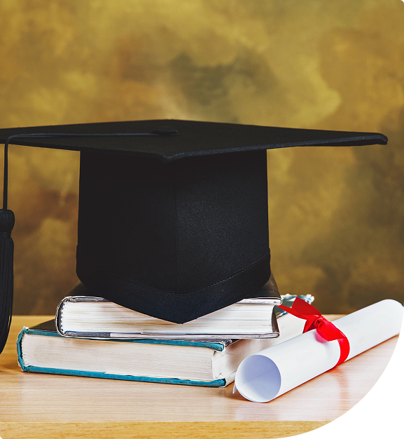 Graduation cap, books, and diploma on table.