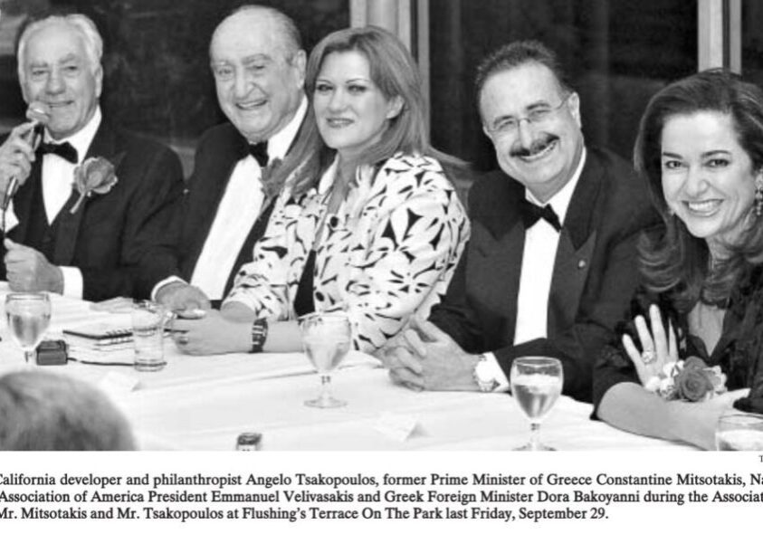Three people in formal attire smiling at a dinner event.