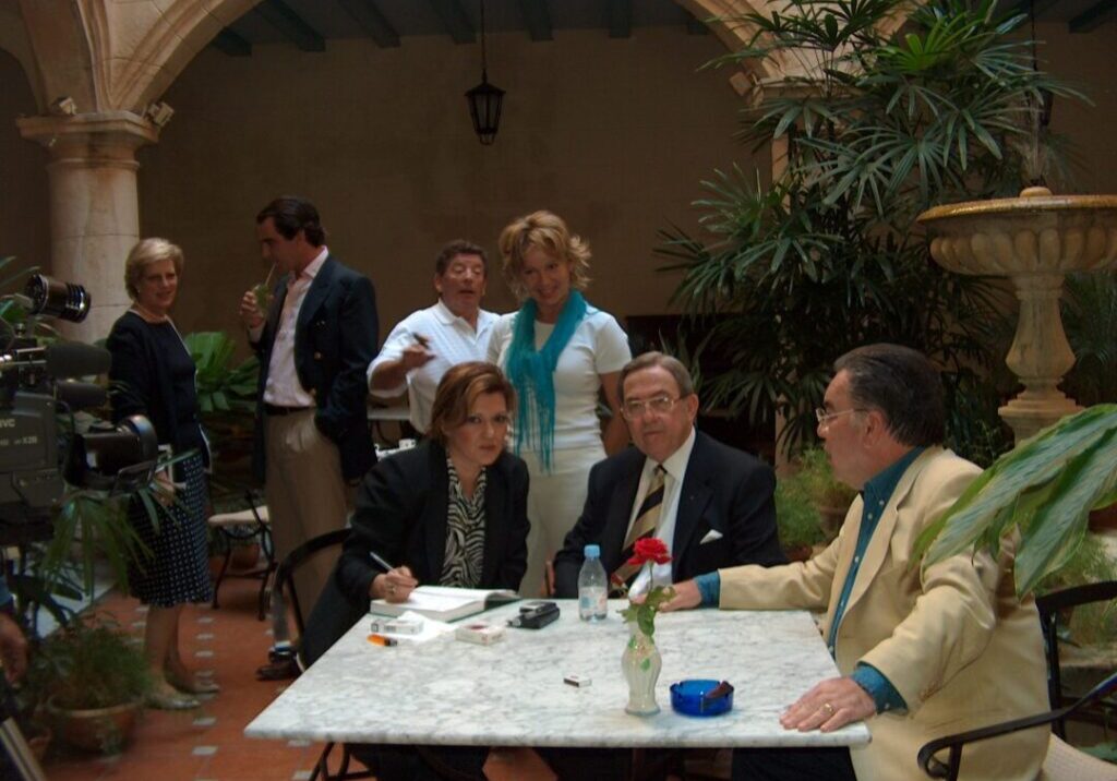 People socializing at an outdoor café with drinks and conversation.